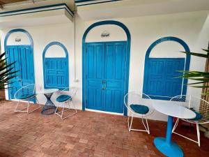 a group of blue doors with chairs and a table at Homestay Văn Vĩnh Hy cơ sở 3 in Ninh Hải