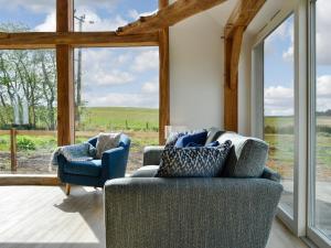 a living room with two chairs and a large window at Greenford Farm in Newtyle