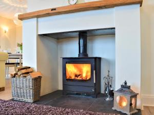 einen Kamin im Wohnzimmer mit Herd in der Unterkunft Merrywind in Beadnell