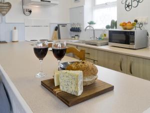 two glasses of wine and cheese on a counter in a kitchen at The Loft in Amlwch