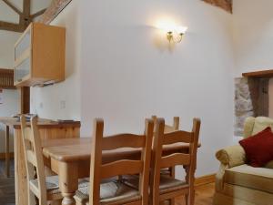 a kitchen with a wooden dining room table and chairs at Barn Owl Cottage in Cromford