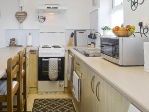 a kitchen with a stove and a microwave at The Loft in Amlwch