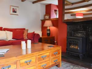 a living room with a couch and a fireplace at Pineview Cottage in Downderry