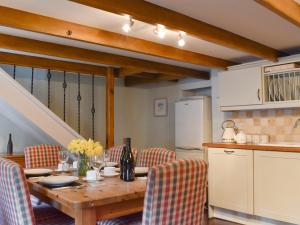 a kitchen with a wooden table with chairs and a tableablish at Pineview Cottage in Downderry
