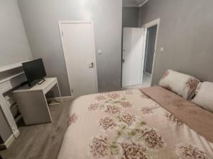 a bedroom with a bed and a desk and a television at 151 Felixstowe road in Edmonton