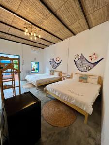 a room with two beds and a table at Homestay Văn Vĩnh Hy 3 in Ninh Hải