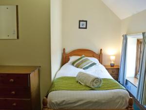 a bedroom with a bed with a green blanket on it at Percheron Cottage in Sewerby +8 photos