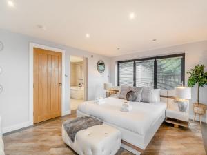 a bedroom with a large white bed and a bathroom at North Plain Barn in Bowness-on-Solway