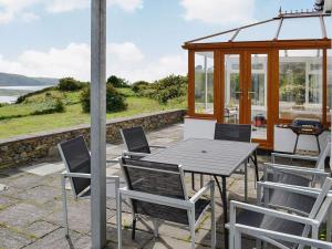 a table and chairs on a patio with a gazebo at Cae-Fadog Fach in Barmouth