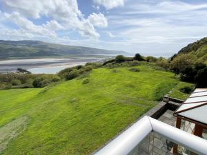 a view of a grassy hill next to a river at Cae-Fadog Fach in Barmouth