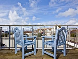 two blue chairs and a table on a deck at Sea Glimpses in Saint Columb Minor