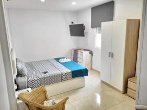 a small bedroom with a bed and a cabinet at LAS 7 ISLAS, BARRANCO DE ADEJE in Adeje