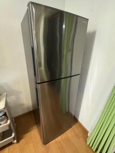 a stainless steel refrigerator sitting in a kitchen at Otsu guest house3 in Chikusei