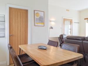 a living room with a table and chairs and a couch at Seascape Cottage in Allonby