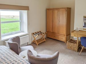 a bedroom with a bed and a desk and a window at Seascape Cottage in Allonby +14 photos