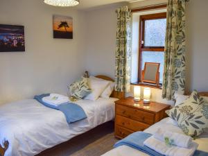 ein Schlafzimmer mit zwei Betten und einem Fenster in der Unterkunft Capstan Cottage in Whitby