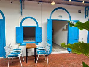 two chairs and a table in front of a building with blue doors at Homestay Văn Vĩnh Hy cơ sở 3 in Ninh Hải