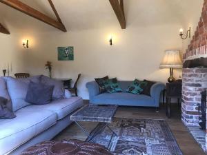 un soggiorno con due divani e un tavolo di The Old Cow Shed a Thorndon