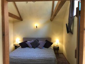 una camera da letto con letto e cuscini viola di The Old Cow Shed a Thorndon Altre 8 foto