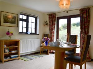 a living room with a table and a window at Tripp Cottage in Saint Neot