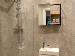 une salle de bain avec un lavabo et une douche en verre dans l'établissement Terraughtie Cottage East-Uk31767, à Terreglestown