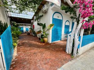 a building with blue doors and a brick walkway at Homestay Văn Vĩnh Hy cơ sở 3 in Ninh Hải