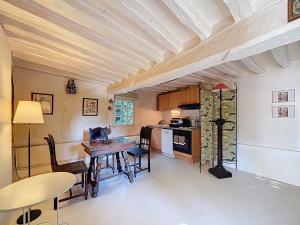 a kitchen with a table and chairs in a room at la chaumière de Vieux Port in Vieux-Port