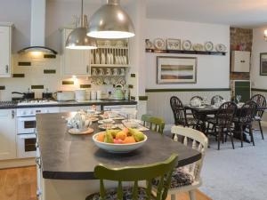 a kitchen with a table with a bowl of fruit on it at Quarryman's Cottage in Belford