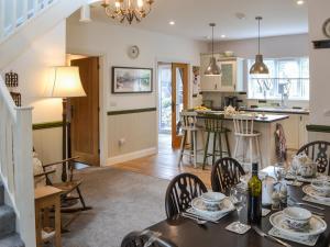 a kitchen and living room with a table and chairs at Quarryman's Cottage in Belford