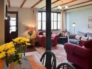 a living room with a couch and a table with flowers at Rose Cottage - E1494 in Scalby