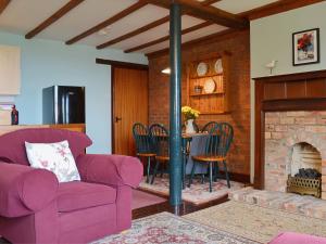a living room with a purple couch and a fireplace at Rose Cottage - E1494 in Scalby