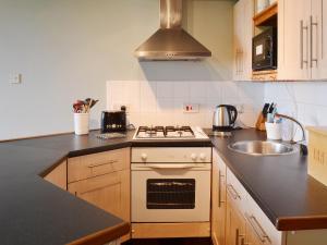 a kitchen with a stove and a sink at Rose Cottage - E1494 in Scalby