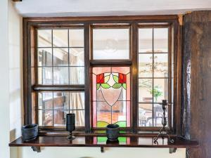 a stained glass window on a table with candles at Pinley Hill House in Shrewley