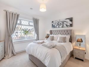 a bedroom with a white bed with a window at Heritage Cottage in Flamborough +14 photos