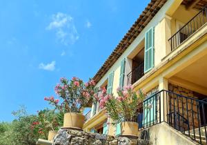 a building with potted plants on the side of it at Provence villa with heated pool and amazing view in Montauroux