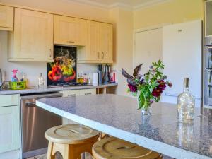 a kitchen with a counter with a vase of flowers on it at Millstream - Uk45183 in Penton