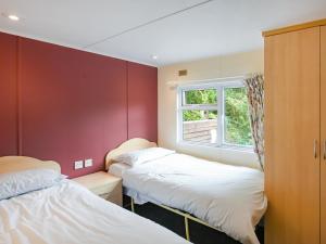 two beds in a room with a window at The Squirrels Drey C32 - Uk45927 in Newtown