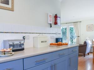 a kitchen with blue cabinets and oranges on a counter at Chy Morvoren in Falmouth