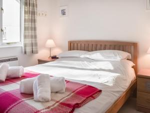 a bedroom with a large white bed with towels on it at Chy Morvoren in Falmouth +20 photos