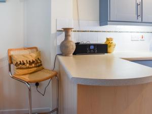 a kitchen counter with a chair and a vase on it at Chy Morvoren in Falmouth
