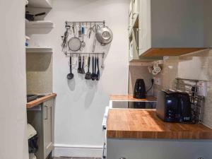 a kitchen with utensils hanging on a wall at Bwth Carron in Barmouth +12 photos