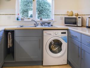 a kitchen with a washing machine and a sink at Chy Morvoren in Falmouth
