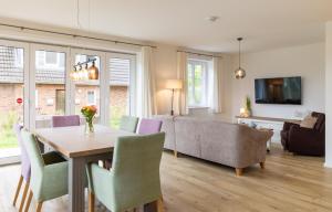a living room with a table and chairs and a couch at Jöri Hüs 1 in Nebel +20 photos