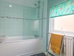 a bathroom with a shower and a tub and a sink at Hysryb Cottage in Cardiff