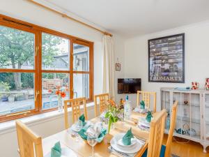 ein Esszimmer mit Tisch und Stühlen und einem Fenster in der Unterkunft Caldon Cottage in Cromarty