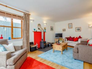 ein Wohnzimmer mit zwei Sofas und einem Fernseher in der Unterkunft Caldon Cottage in Cromarty