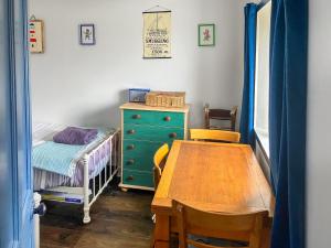a room with a table and a bed and a desk at The Captains in Bettyhill