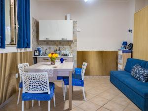 a kitchen with a table and chairs and a blue couch at Il Paradiso Verde in Pagani