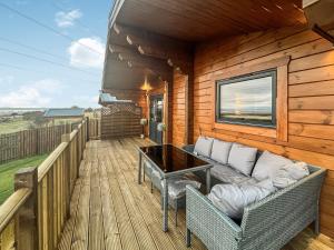a porch with a couch and a table on a deck at Coo Lodge - Uk48430 in Falkirk