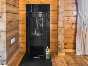 a stove in a room with a wooden wall at Coo Lodge - Uk48430 in Falkirk